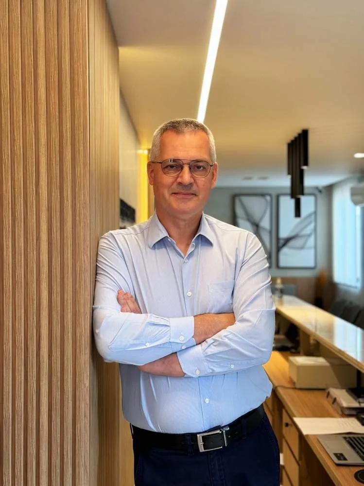 Dr. Leonardo Zacher em pé na recepção da Clínica Menezes & Zacher, Esteio/RS